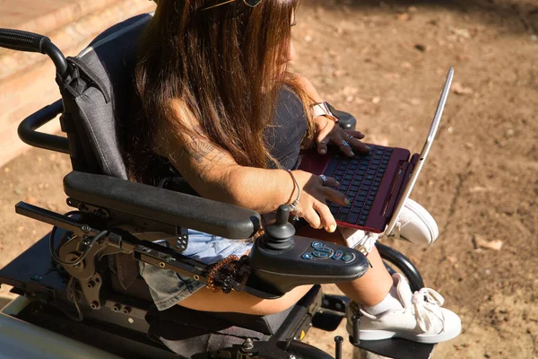 실외에서 노트북 컴퓨터와 휠체어를 일하던 장애인 여성이었습니다 기본적 — 스톡 사진