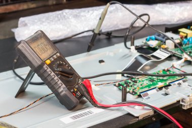 Mağazadaki mühendis veya teknisyen tarafından LCD TV 'nin sökülmesi ve onarılması, seçici odaklanma.