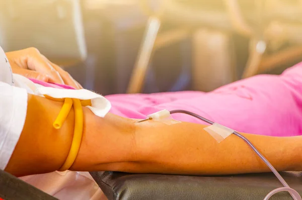 人の腕が針で血を寄付して命を救う世界の献血者のための昼間のイメージで病院での医学研究6月14日 — ストック写真