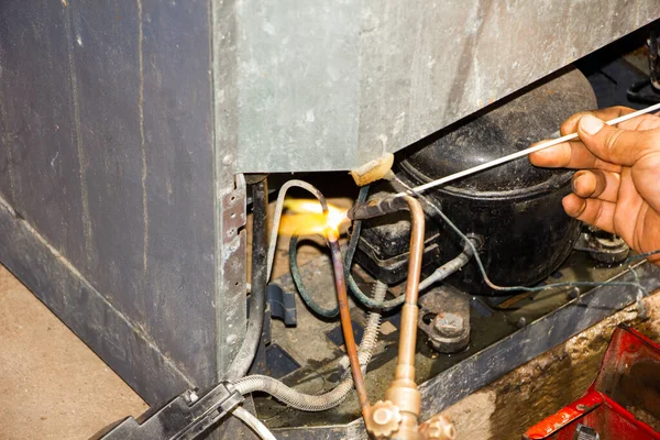 Bakım atölyesinde kaynak yaparak ve vakum yaparak teknisyen onarım buzdolabı