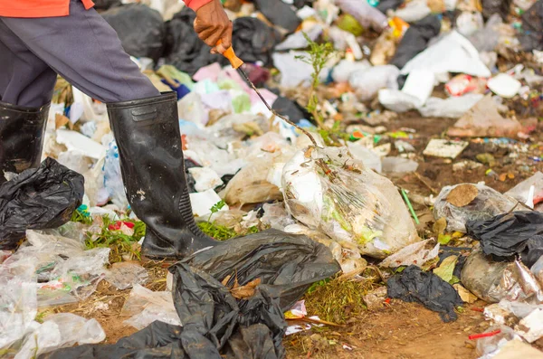 man collects garbage on garbage dump close up. The concept of Earth Day.