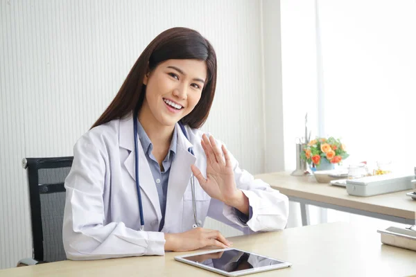 Medico Donna Asiatica Seduta Ufficio Sorridi Felicemente Alza Mano Salutare — Foto Stock