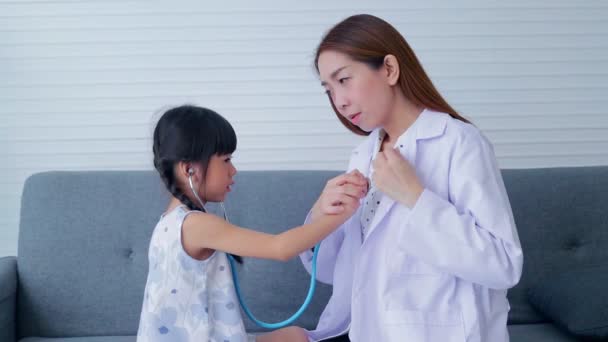 아시아의 아름다운 의사는 청진기를 박동을 체크하는 소녀를 가르친다 병원에서의 서비스의 — 비디오