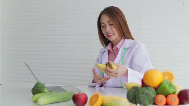 Krásný Asijský Nutriční Pracovník Sedí Bílém Stole Různými Druhy Ovoce — Stock video