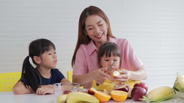 Bela Mãe Descasca Maçãs Para Duas Filhas Jovens Sentadas Uma — Vídeo de Stock