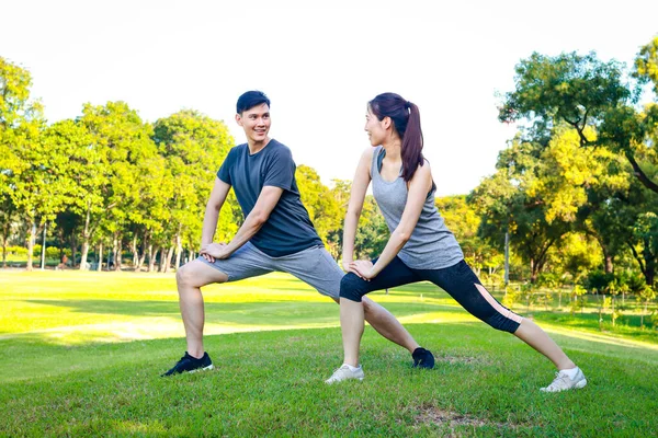 Asyalı erkek ve kadın çiftler sabah parkta egzersiz yapıyor. Sağlıklılar, gülümsüyorlar ve mutlular. fitness konsepti, sağlık hizmeti