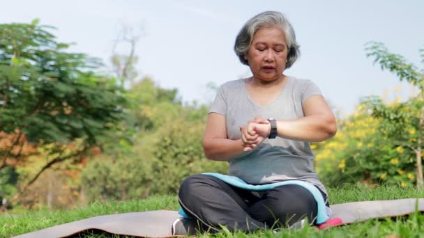 Asian Elderly Woman Exercising Park Morning Look Time Your Wrist — Stockvideo