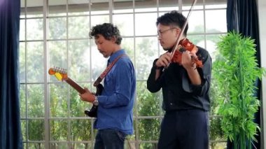 İki Asyalı adam bir müzik çalışma odasında birlikte klasik enstrüman ve gitar çalıyor. İkisi de müzik çalmayı seviyor. Canlı müzik ve gruplar çalma kavramı