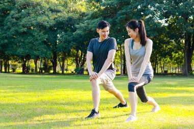 Asyalı erkek ve kadın çiftler sabah parkta egzersiz yapıyor. Sağlıklılar, gülümsüyorlar ve mutlular. fitness konsepti, sağlık hizmeti