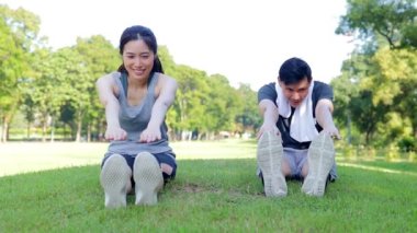 Asyalı erkek ve kadın çiftler sabah parkta egzersiz yapıyor. Sağlıklılar, gülümsüyorlar ve mutlular. fitness konsepti, sağlık hizmeti