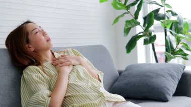 Asyalı bir kadın evdeki kanepede yatıyordu kalbinde keskin bir ağrı vardı sanki göğsüne bir şey bastırıyormuş gibi. Acısını dindirmek için ellerini göğsüne bastırmak için kullandı. Kalp hastalığı. 