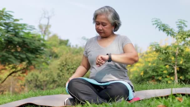 Asian Elderly Woman Exercising Park Morning Look Time Your Wrist — Stockvideo