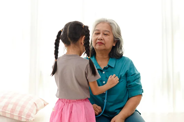 Girl Grandma Together Home She Holds Stethoscope Check Her Heart — Stock Photo, Image