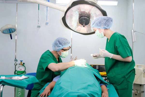 Equipo Cirujanos Profesionales Asiáticos Operar Paciente Acostado Una Cama Quirófano — Foto de Stock