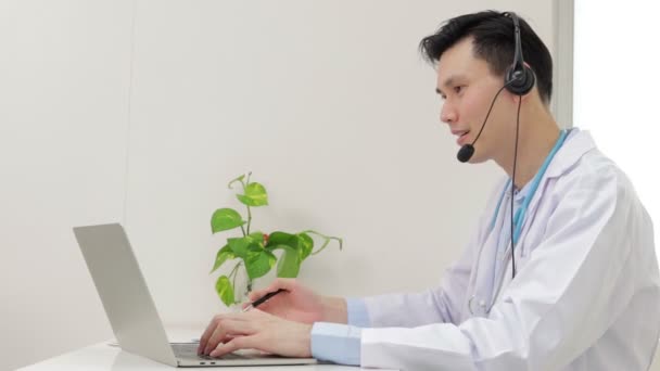 亚洲男医生笑得很美通过笔记本电脑为网上交谈的病人提供治疗服务 网上医生的概念 复制空间 — 图库视频影像