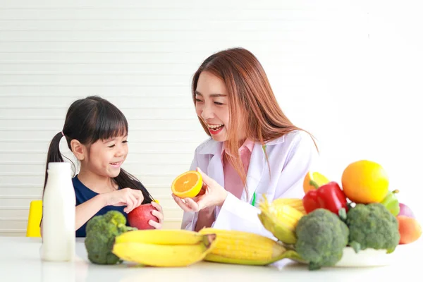 학령기 아동을 아름다운 영양학자 의사는 소녀에게 채소의 유익에 설명한다 아이의 — 스톡 사진
