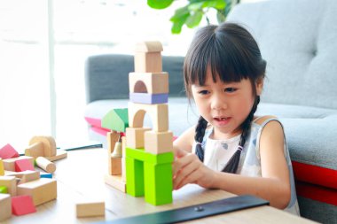 cute little asian girl Smiling happy playing with wooden toys. concept of learning and developing skills of school-aged children