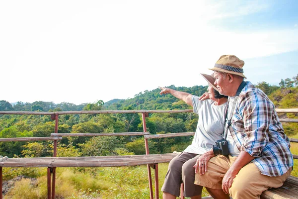 亚洲一对老年夫妇喜欢旅行 坐在山上欣赏美丽的自然景观 旅游概念 退休生活的快乐 复制空间 — 图库照片