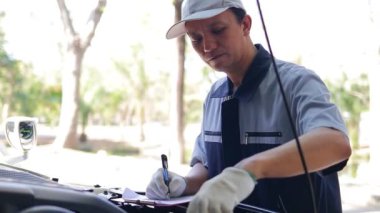 Araba tamircisi arabanın kötü durumunun kontrol listesini kaydediyor. Araba bakımı denetimi ve sigortası kavramı. araba garajı