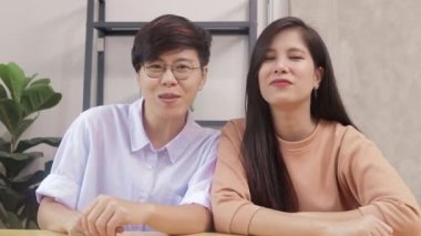 Asian LGBT couples live together at home. Greet your friends through online videos. group of people who are sexually diverse