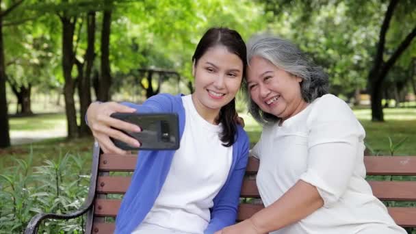 Elderly Mother Asian Daughter Lounging Park Happy Vacation Holding Smartphones — Stok video