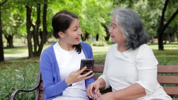 Elderly Mother Asian Daughter Lounging Park Happy Vacation Holding Smartphones — Video Stock