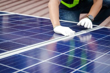 Asyalı teknisyenler güneş pillerini elektrik üretmek ve dağıtmak için kuruyorlar. Enerji teknolojisi konsepti. Boşluğu kopyala