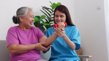Female doctor doing physical therapy for elderly female patients Lifting dumbbells strengthens muscles. Concept of medical services in hospitals. physical therapy center rejuvenate the elderly