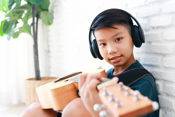 在家里学习音乐的亚洲男孩他正在练习弹吉他 音乐学校的概念 儿童教育 — 图库照片