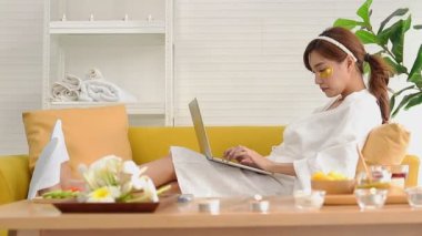 Güzel Asyalı kadın evde spa yapıyor ve ayrıca çalışıyor. Altın ipek bitkisel krem, yüz maskesi, deriyi besler, kolajen ve elastin üretmek için deriyi uyarır. güzellik konsepti