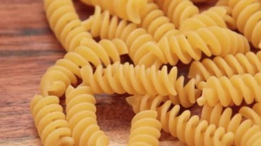 Ahşap zemin üzerinde çiğ fusilli yığını