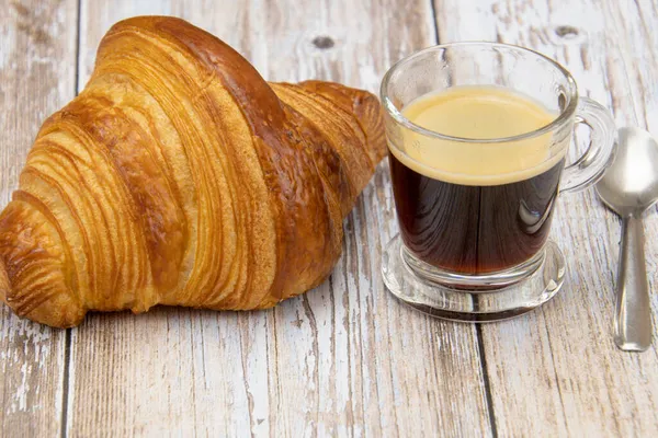 Croissant Und Tasse Kaffee Auf Einem Tisch — Stockfoto