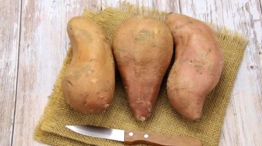 Tahta bir masada birkaç tatlı patates.