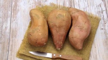 Tahta bir masada birkaç tatlı patates.