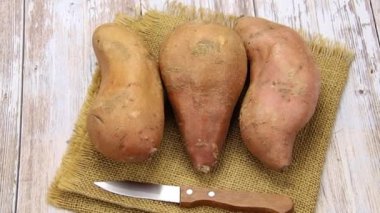 Tahta bir masada birkaç tatlı patates.