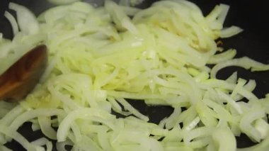 Tavada doğranmış soğan pişirmek.