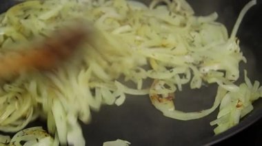 Tavada doğranmış soğan pişirmek.