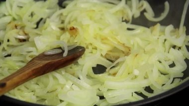 Tavada doğranmış soğan pişirmek.