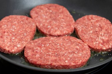 Tavada kıymalı biftek pişiyor.