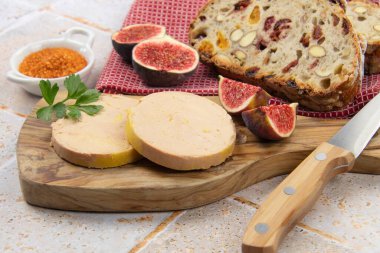 Kesme tahtasının üzerinde foie gras dilimleri.