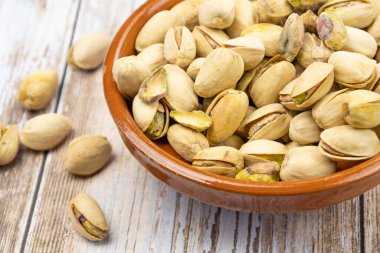 Ahşap arka planda bir kasede fıstık.