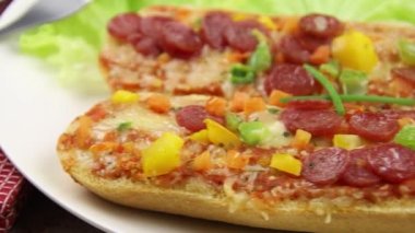Salamlı, peynirli ve sebzeli pizza sandviçleri.