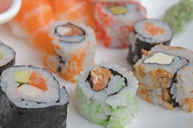 Somon ve avokado ile suşi ruloları. Bir tabak maki. 