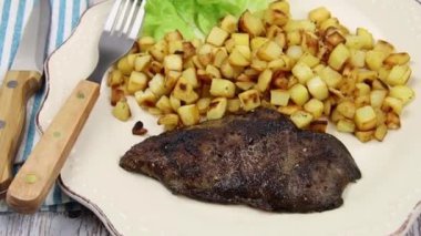 Tabağında ciğer olan patates kızartması.