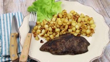 Tabağında ciğer olan patates kızartması.