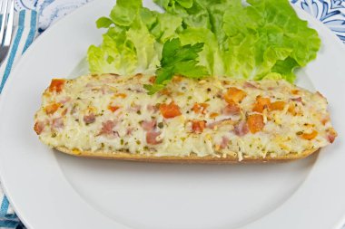 Salamlı, peynirli ve sebzeli baget pizza.