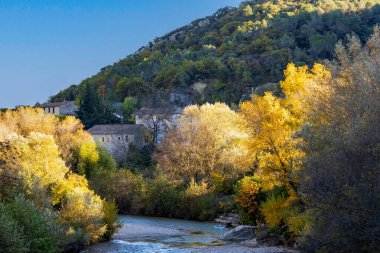 Dağlardaki güzel sonbahar manzarası, küçük nehir ve sarı yapraklı ağaçlar. 