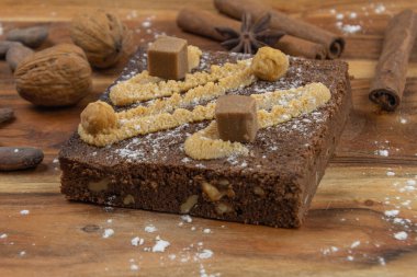 Cevizli çikolatalı kek, tarçınlı çubuk ve tahtanın üzerinde kakao çekirdeği. 