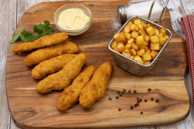 Sos ve patates kızartmasıyla kızartılmış kızarmış tavuk şeritleri. 