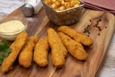 Sos ve patates kızartmasıyla kızartılmış kızarmış tavuk şeritleri. 